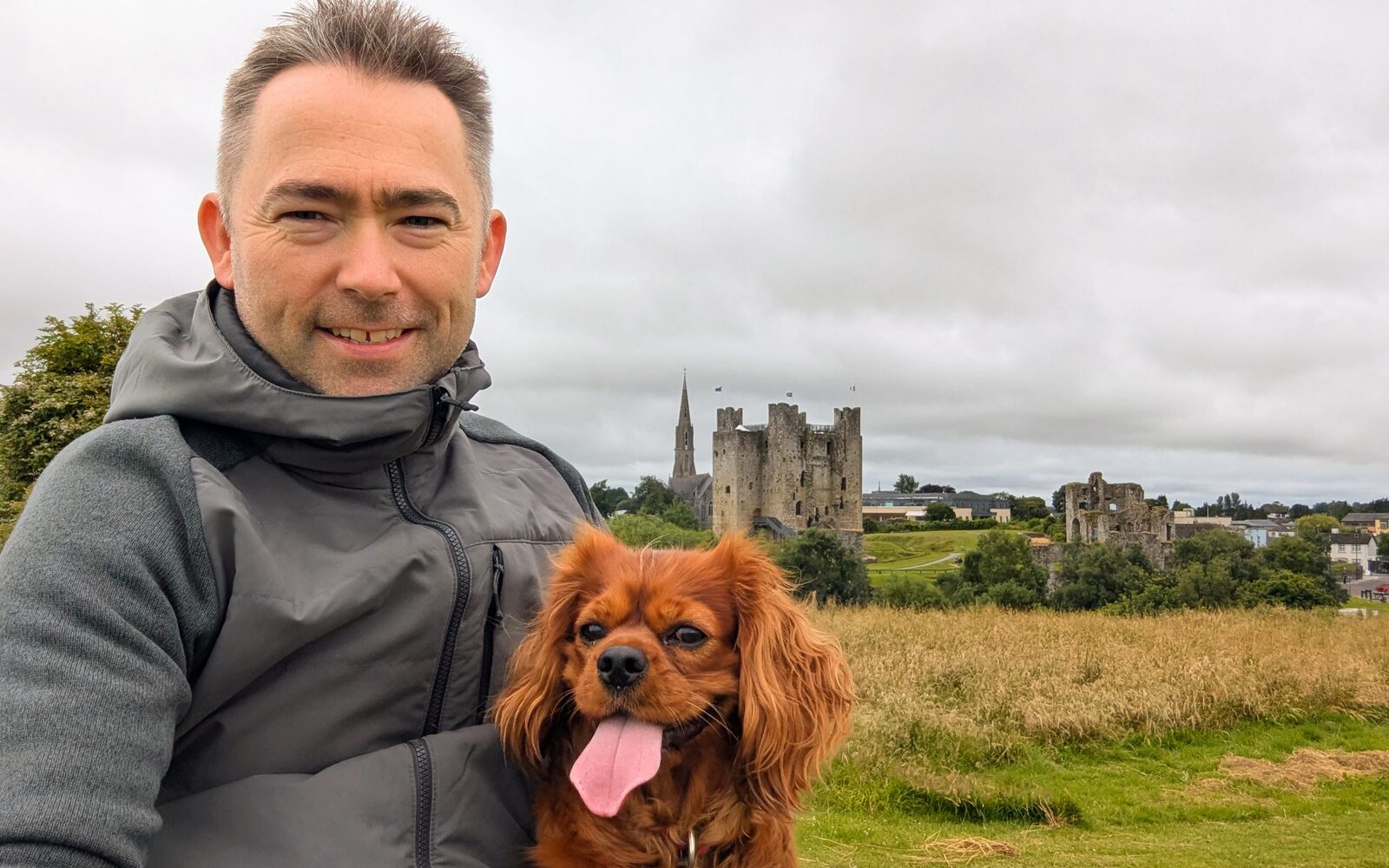 Cormac with his Cavalier King Charles Spaniel, Sunny, in front of Trim Castle in County Meath, Ireland