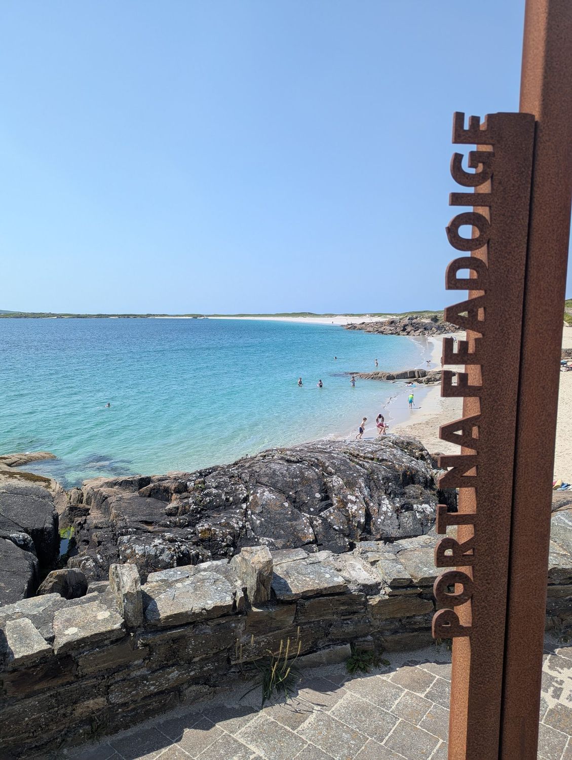 The rusted Trá na Feadóige Irish-language sign at Gurteen Beach